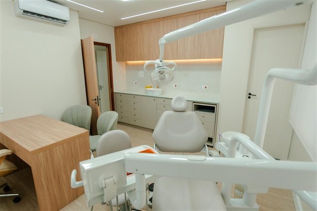 Consultório odontológico claro com cadeira e equipamentos modernos